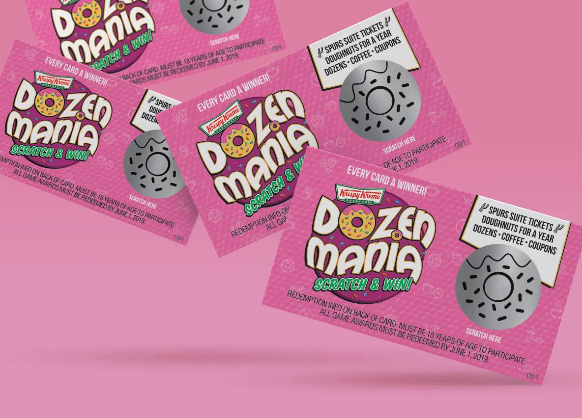 Pink Krispy Kreme Dozen Mania scratch and win cards fanned across a pink surface